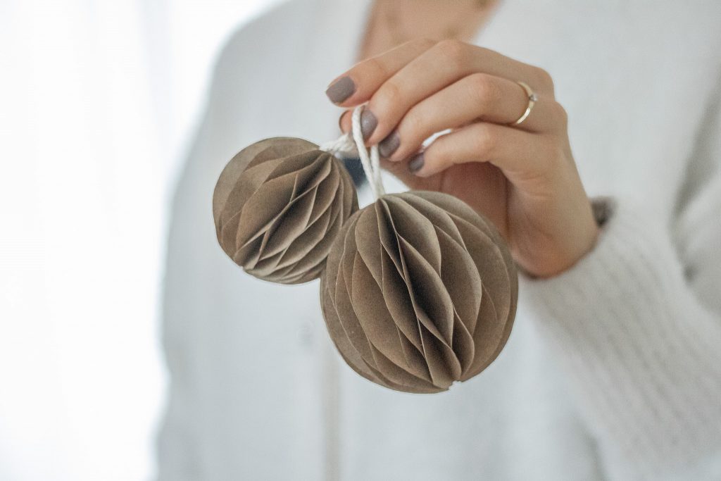Weihnachtskugeln in der Hand aus Papier.