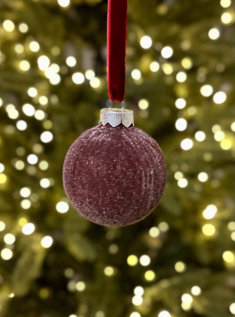 Fertige dunkelrote Samtkugel am Weihnachtsbaum.