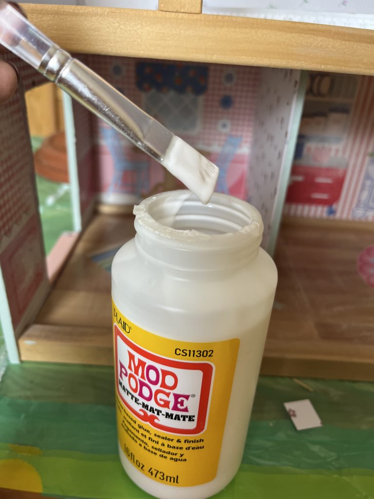 Pinsel wird in Modpodge getaucht.