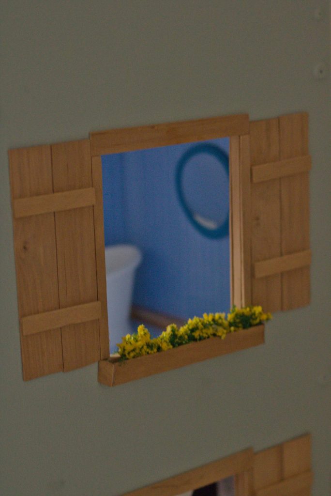Fertige Fenster mit Fensterläden und Blumenkasten.