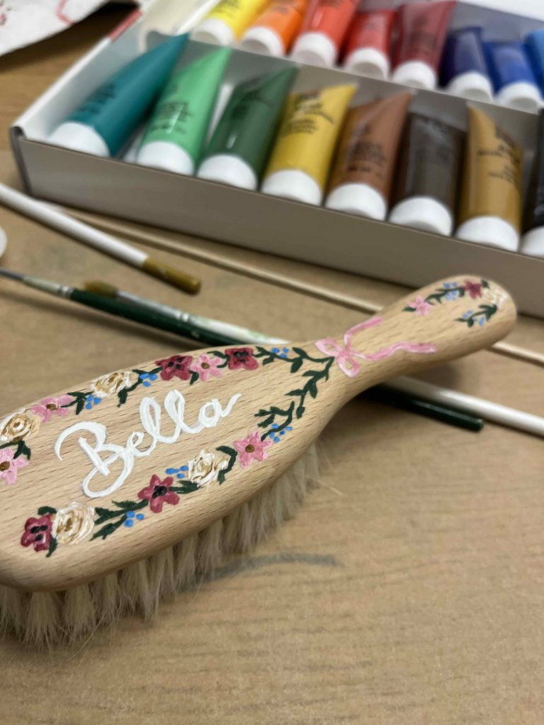 Holz Babybürste bemalt mit Blumen und Namen.