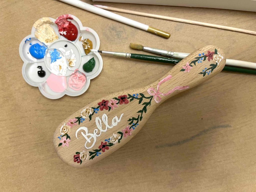 Holz Babybürste bemalt mit Blumen und Namen.